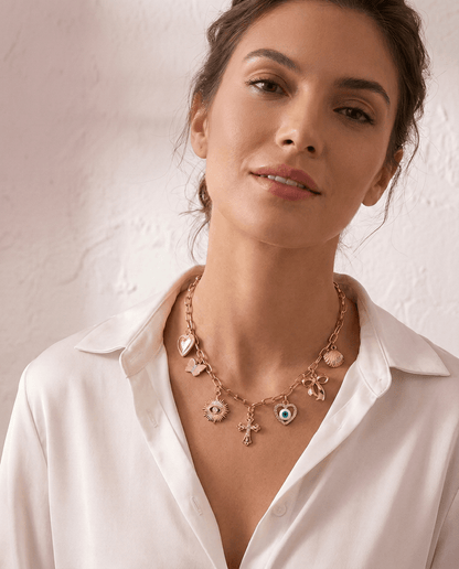 Love & Luck Charm Necklace by Frosted Feminine, layered gold charm necklace styled on a feminine neckline